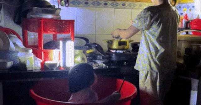 Đà Nẵng ngập lụt, mẹ trẻ đặt con vào chậu vừa trông vừa nấu vội bữa cơm chiều